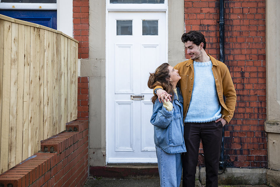 Couple standing outside a property