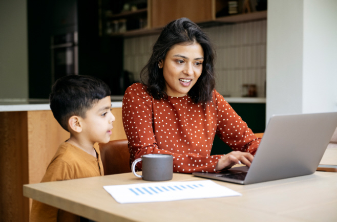 A mother and son looking at their laptop