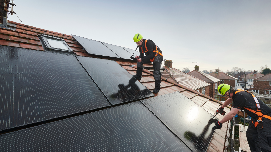 An installer fitting a solar panel to a roof